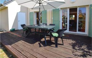 einem Tisch mit Stühlen und einem Sonnenschirm auf einer Terrasse in der Unterkunft 4 Bedroom Cozy Home In Port-en-bessin-huppain in Huppain