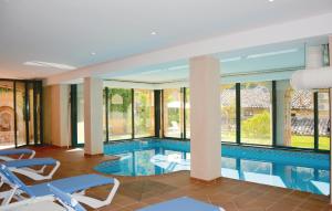 una piscina en un hotel con sillas y ventanas en 4 Bedroom Stunning Home In Fornalutx, en Fornalutx