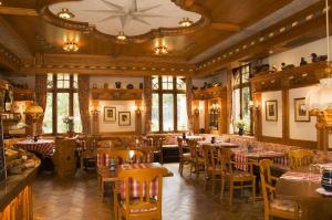 - un restaurant avec des tables et des chaises dans une salle dans l'établissement Hôtel du Parc, Restaurant, Spa & Wellness, à Niederbronn-les-Bains