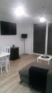 a living room with a couch and a table at Apartament Morski przy plazy in Darłówko