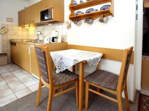 une petite cuisine avec une table et deux chaises dans l'établissement Apartment, Dornumersiel, à Dornumersiel