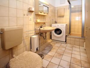 La salle de bains est pourvue d'un lavabo et d'un lave-linge. dans l'établissement Apartment, Dornumersiel, à Dornumersiel