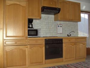 a kitchen with wooden cabinets and a microwave at Ferienwohnung Hippach - Monika Sporer in Hippach