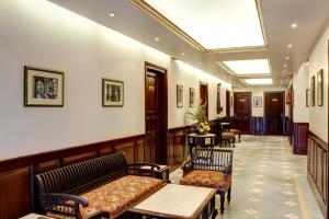 un pasillo con bancos y mesas en un edificio en Palace On Ganges - Heritage Hotel, en Varanasi