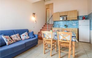 un soggiorno con divano blu e una cucina di Pet Friendly Home In Cavo With House Sea View a Cavo
