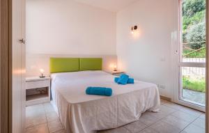 una camera da letto con un letto con cuscini blu di Pet Friendly Home In Cavo With House Sea View a Cavo