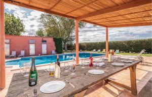einen Tisch mit Weinflaschen und Gläsern auf einer Terrasse in der Unterkunft 8 Bedroom Amazing Home In Riudellots in Riudellots de la Selva