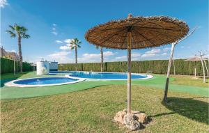 トレビエハにあるStunning Apartment In Torrevieja With House A Panoramic Viewのスイミングプール横の芝生の傘