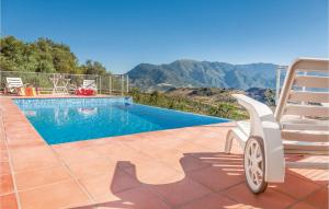 a swimming pool with a chair next to a chair at Gorgeous Home In Cádiz With Wifi in El Gastor +25 photos