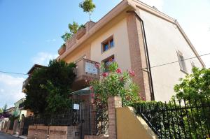 a building with a fence and flowers in front of it at Domus Primavera in Scerne