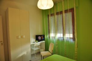 a green room with a desk and a bed and a window at Domus Primavera in Scerne