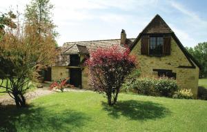 FleuracにあるNice Home In Fleurac With 3 Bedroomsの庭に赤い木がある古い石造りの家