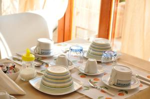 a table with plates and cups and utensils on it at Domus Primavera in Scerne