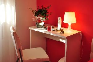 a red room with a table with a lamp and a chair at Domus Primavera in Scerne