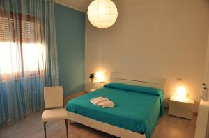 a bedroom with a green bed and a chair at Domus Primavera in Scerne