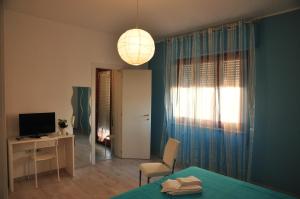 a room with a bed and a desk and a television at Domus Primavera in Scerne