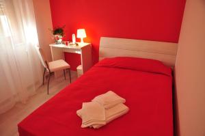 a red bedroom with a red bed and a desk at Domus Primavera in Scerne
