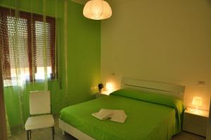 a green bedroom with a green bed and a chair at Domus Primavera in Scerne