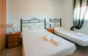 Dos camas en una habitación con dos toallas. en 2 Bedroom Amazing Apartment In Torrevieja, en Torrevieja
