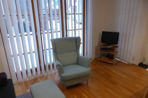 un salon avec une chaise et une télévision dans l'établissement Daniela 8 by SMR Rauris Apartments - inc Spa and National Summercard - near Gondola, à Rauris