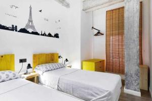um quarto com duas camas e uma imagem da torre Eiffel em Alojamiento Simón 2 em Múrcia