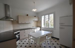 a kitchen with a table and a white refrigerator at Amazing Home In Caromb With 3 Bedrooms And Wifi in Caromb