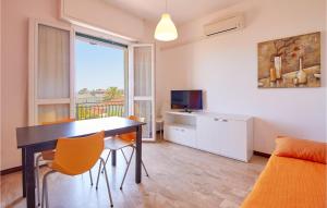 een woonkamer met een tafel en stoelen en een televisie bij Casa Borgo 1 in Pietra Ligure