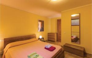 1 dormitorio con 1 cama grande y paredes amarillas en 2 Bedroom Nice Home In Camaiore Lu, en Corsanico-Bargecchia