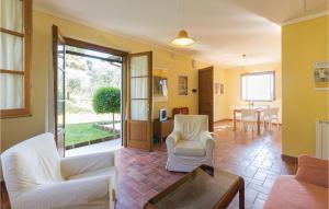 Una sala de estar con sillas blancas y una mesa. en 2 Bedroom Nice Home In Camaiore Lu, en Corsanico-Bargecchia