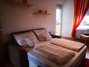 un sofá con almohadas en la sala de estar en Mészáros apartman, en Bük