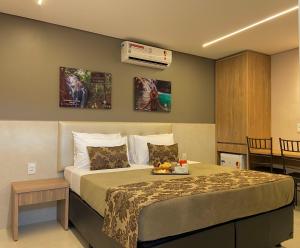 a bedroom with a bed with a tray of fruit on it at Hotel Conviver in Formosa