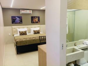 a bedroom with a bed and a bathroom with a sink at Hotel Conviver in Formosa +49 photos