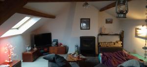 a living room with a couch and a tv at Naturellement Loire ! in Saint-Martin-de-la-Place