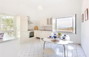 a white kitchen with a table and chairs at Villa La Limonaia in Sorrento