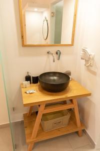 a bathroom sink with a black bowl on a wooden table at Fragoulis Village in Parasporos