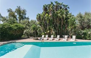 a group of chairs sitting next to a swimming pool at Castello Mortellito in Spadafora