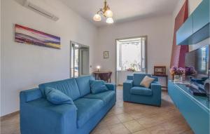 a living room with a blue couch and two chairs at Villa Odabella in Rongolisi