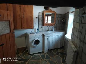 uma casa de banho com uma máquina de lavar roupa e um lavatório em Afrodite's House-Restaurated Oil Factory em Ayiá