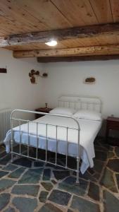 a bed in a bedroom with a wooden ceiling at Afrodite's House-Restaurated Oil Factory in Ayiá