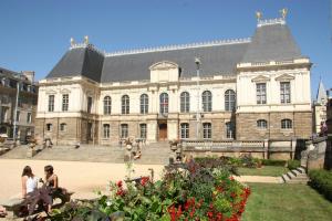 a large building with people sitting in front of it at Hotel ibis Rennes Centre Gare Sud in Rennes
