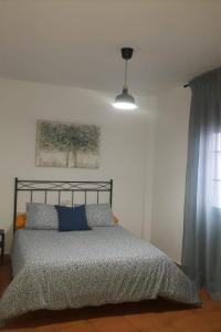 1 dormitorio con cama con almohadas azules y luz en CASA MI SUEÑO, en Grazalema