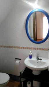 W łazience znajduje się biała umywalka i niebieskie lustro. w obiekcie CASA MI SUEÑO w mieście Grazalema