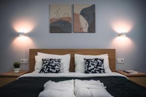- une chambre avec un lit avec des oreillers et deux lumières dans l'établissement Velum Aparts, à Atyraū