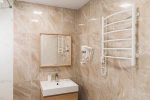 La salle de bains est pourvue d'un lavabo et d'un miroir. dans l'établissement Velum Aparts, à Atyraū