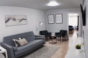 - un salon avec un canapé gris et des chaises dans l'établissement Velum Aparts, à Atyraū