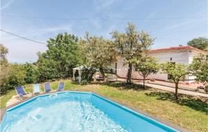 a swimming pool with two chairs and a house at Villa Dellolivo in Sorrento