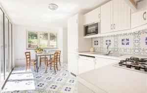a kitchen with white cabinets and a table with chairs at Villa Dell'olivo in Sorrento