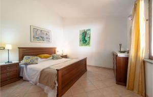 a bedroom with a bed and two pictures on the wall at Nice Apartment In Pieve Di Santa Luce in Pieve di Santa Luce