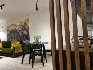 uma sala de estar com uma mesa e um sofá em Apartament Hala Kamienicka em Bielsko-Biala