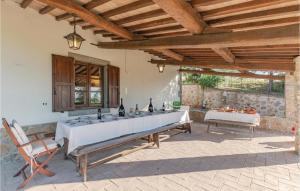 eine Terrasse mit einem langen Tisch und Weinflaschen in der Unterkunft La Querciola in Seggiano
